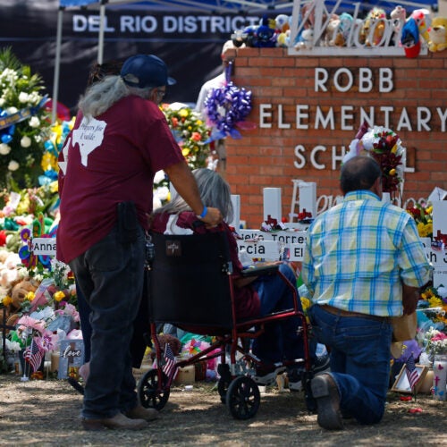 People pay their respects at a memorial outside Robb Elementary School