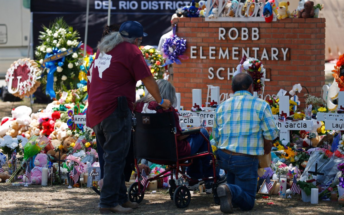 People pay their respects at a memorial outside Robb Elementary School