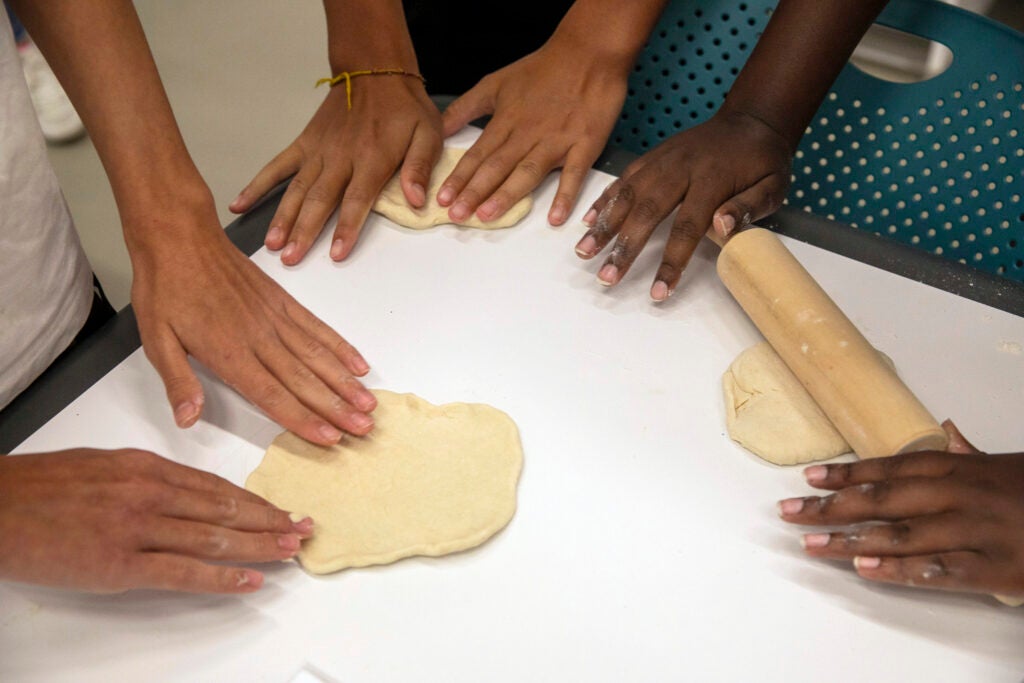 Students roll out dough to make a Ukrainian flatbread.