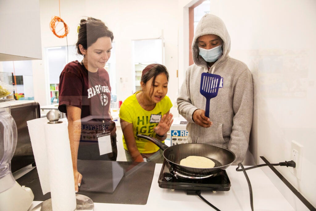 Instructor Nora Birner, M.E. ’20, watches as Regina Qu and Ali Ahmad fry their flatbread.