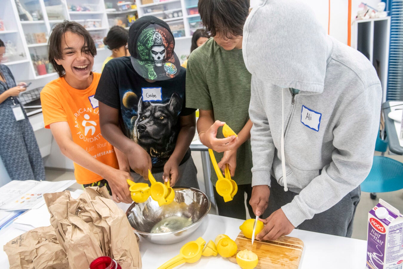 Students squeeze lemons to produce juice.