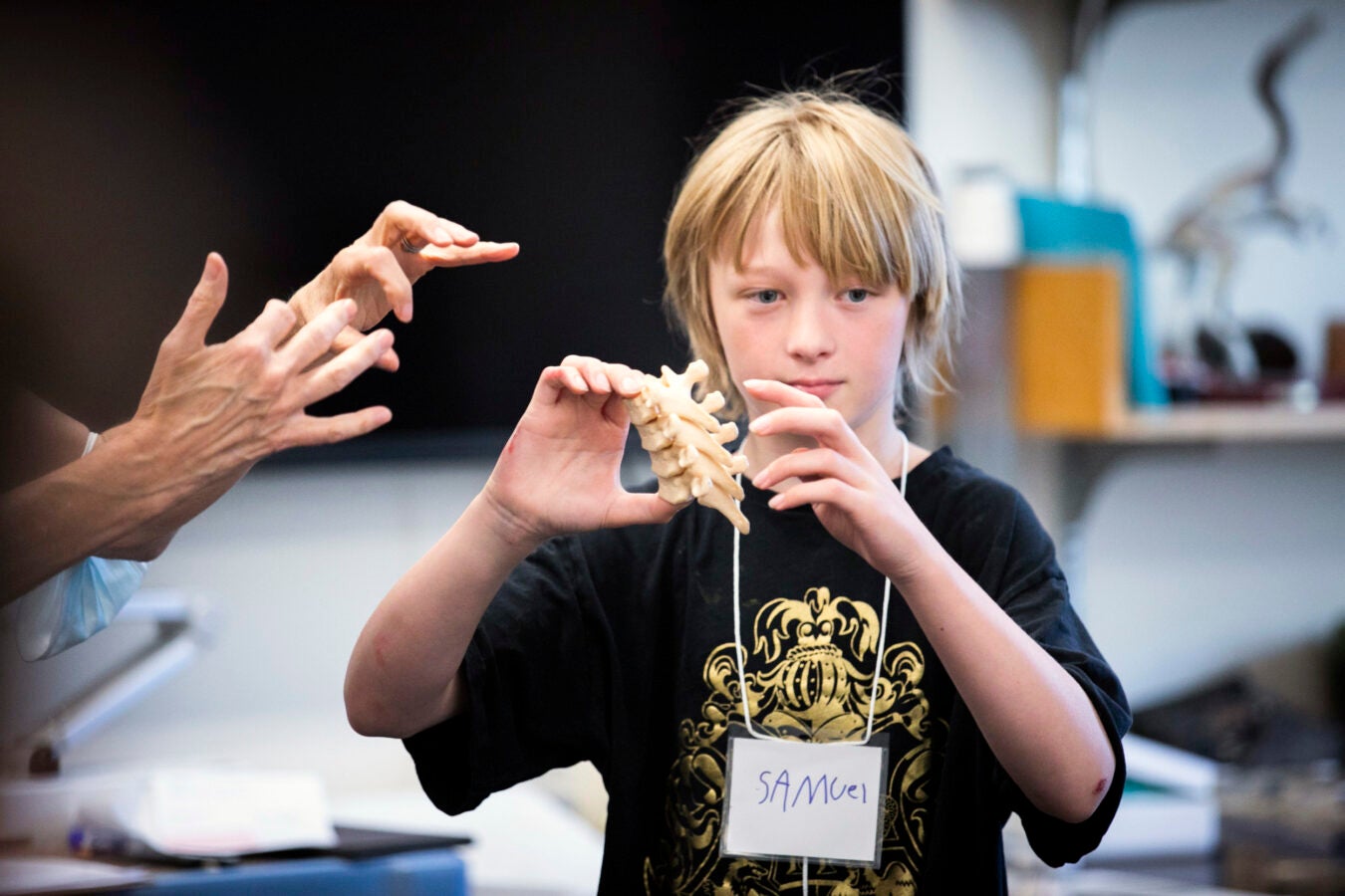 Samuel Jackson holds a skeleton specimen in the classroom.