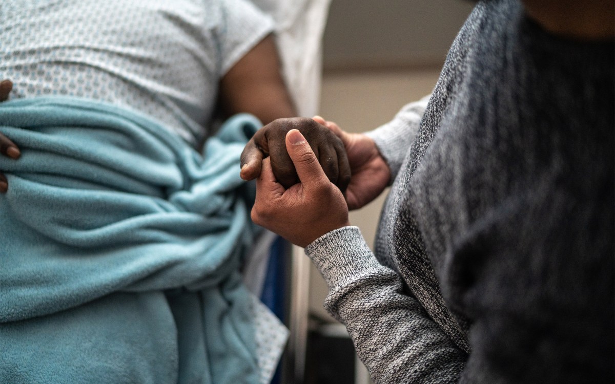 Man holding patient's hand.