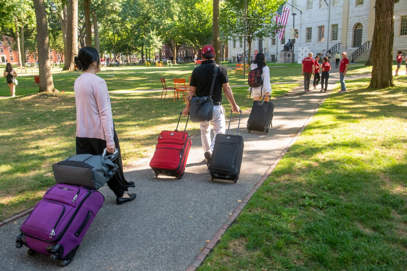 Students bring suitcases into the Yard.