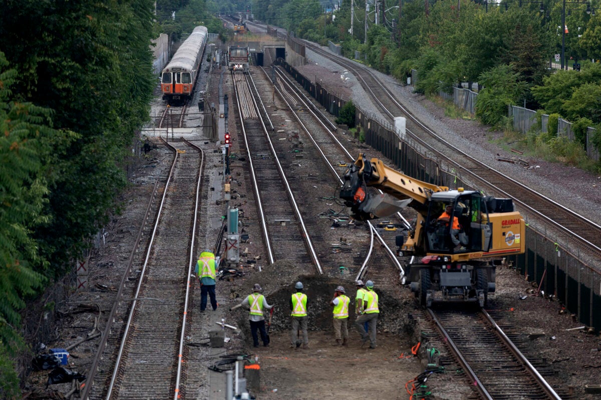 Workers remove sections of Orange Line track in Medford during MBTA shutdown.
