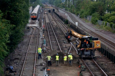 Workers remove sections of Orange Line track in Medford during MBTA shutdown.