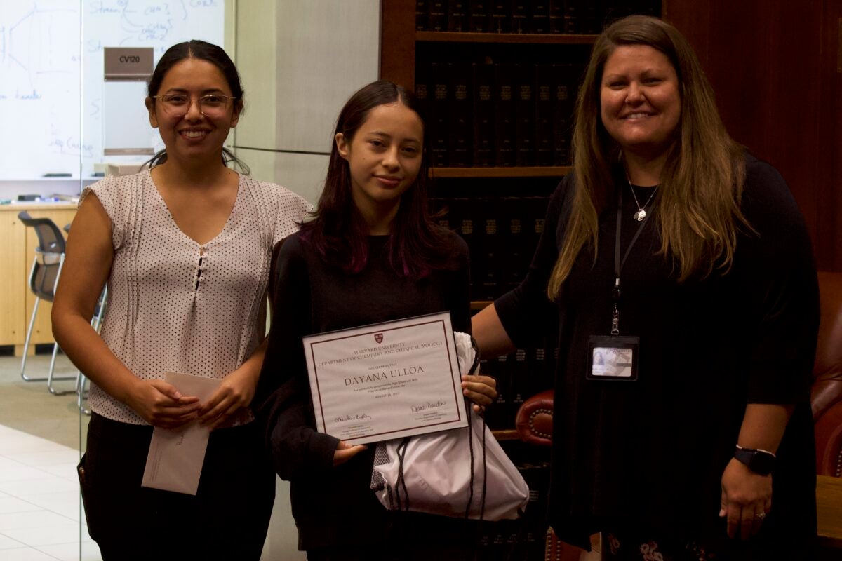 CCB Executive Director and graduate student mentor stand next to a research intern holding her certificate of completion.