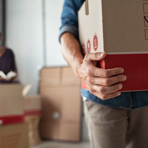 Young couple moving with boxes in hand.