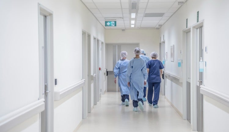Health care workers walking down a hospital corridor.
