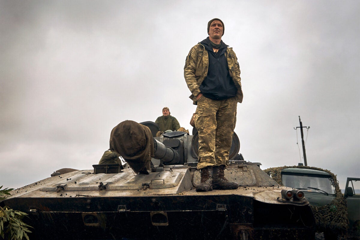 A Ukrainian soldier stands on a tank