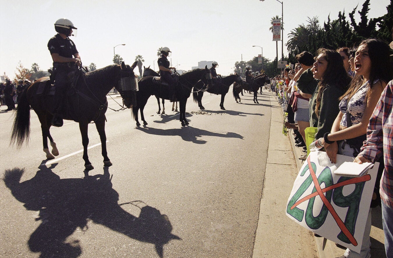 Police on horseback confront Prop 209 protesters.