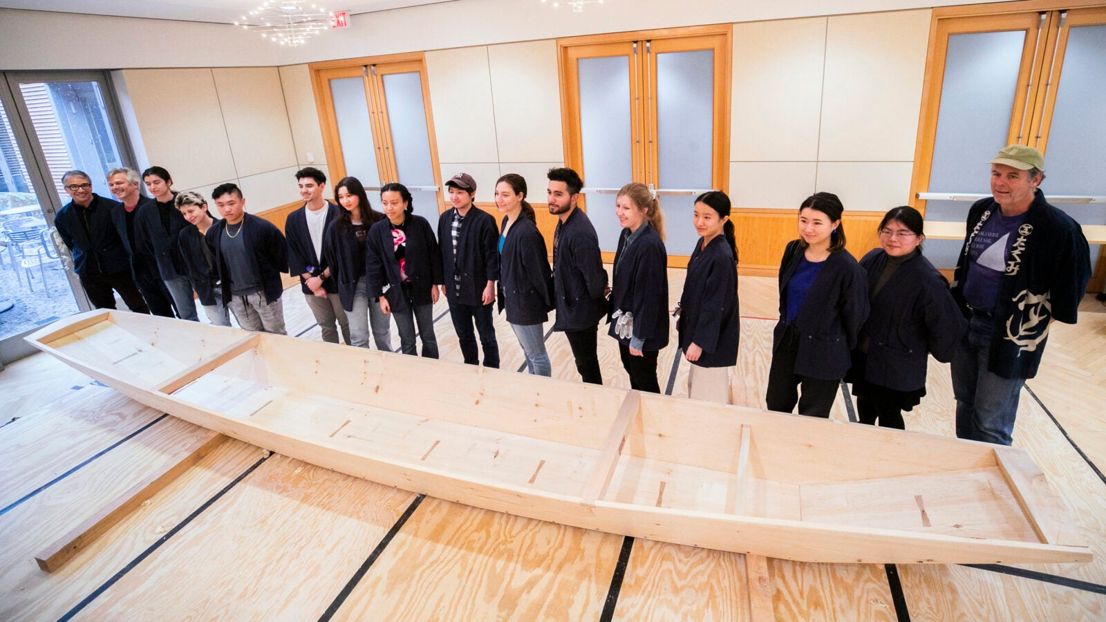Students, Brooks, and members of the Reischauer Institute, who made the project possible, pose with the completed riverboat in the classroom workshop.
