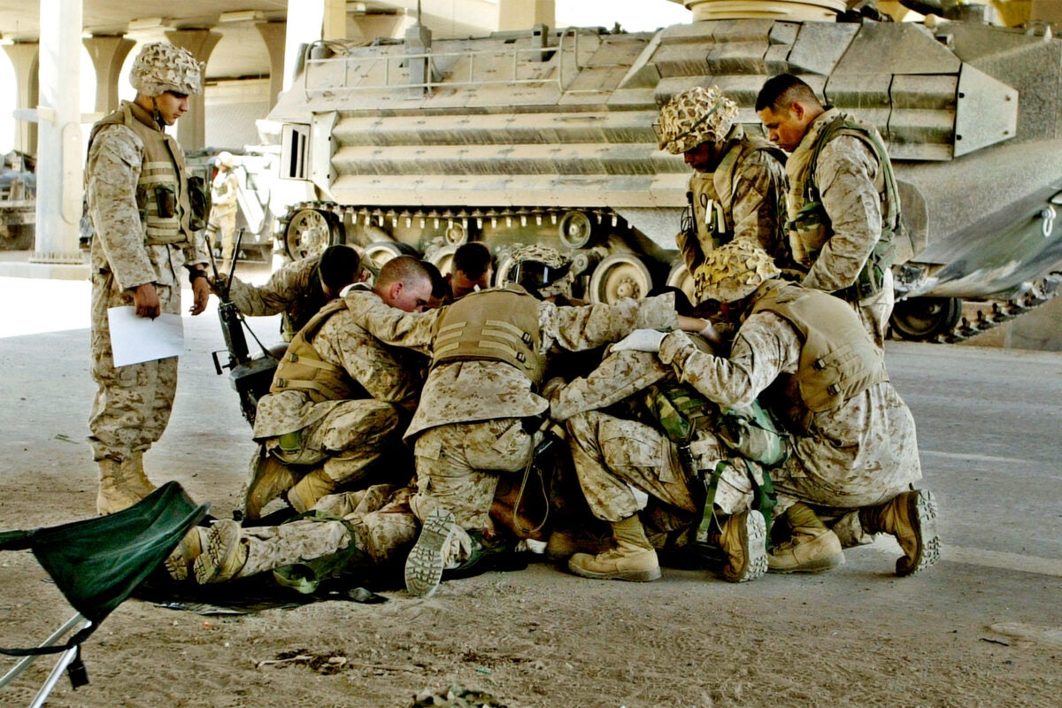 U.S. Marines pray over a fallen comrade.
