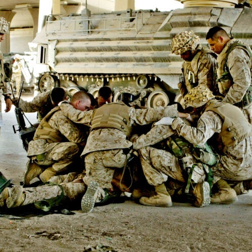 U.S. Marines pray over a fallen comrade.