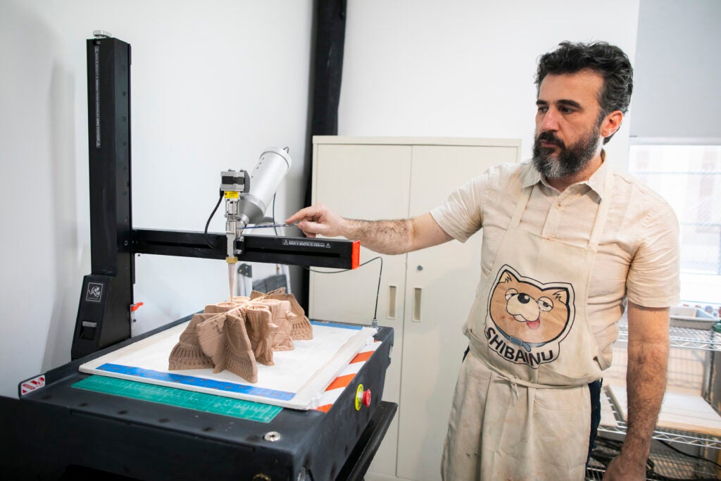 Artist Nicolas Touron builds a ceramic work using a 3D clay printer.