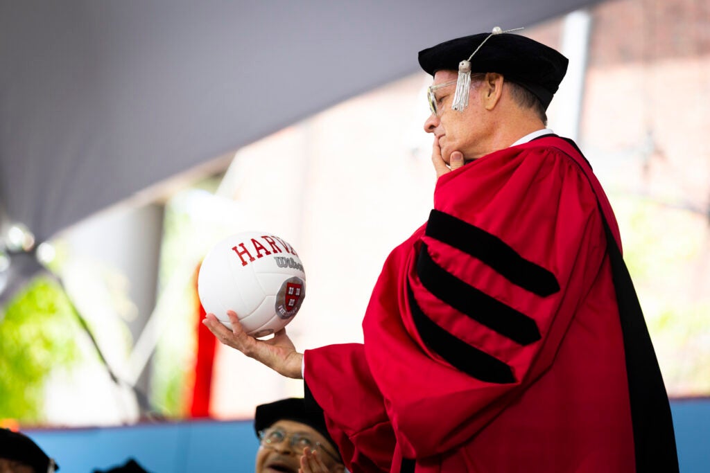 Tom Hanks holds a volleyball.