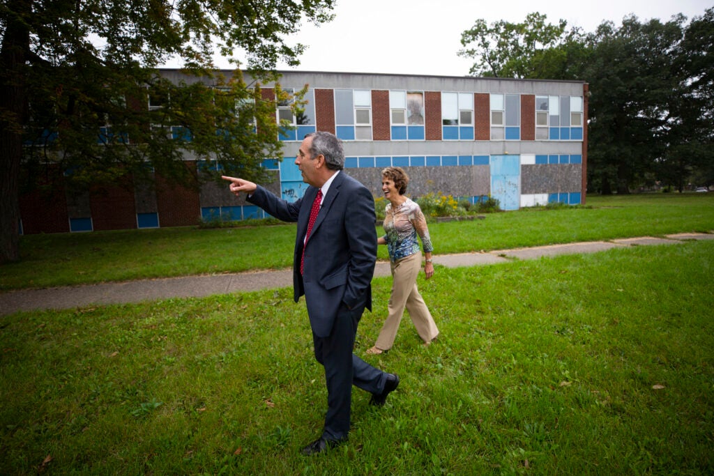 Bacow walks the grounds of one of his former schools with his wife.