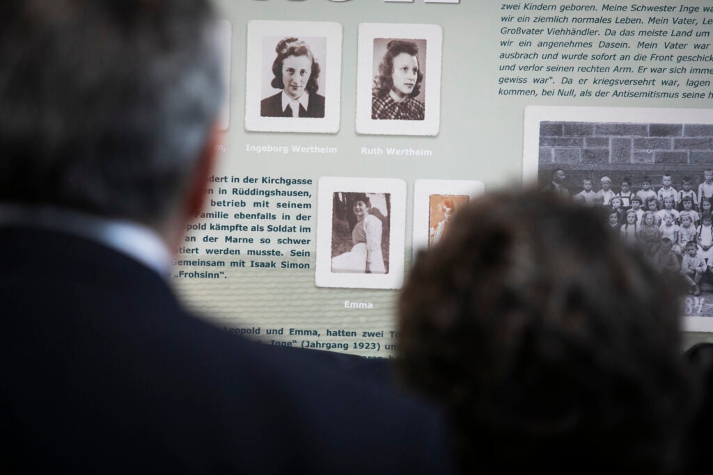 Larry and Adele Bacow look at Holocaust memorial in Londorf, Germany, that features a photo of Larry Bacow's mother, Ruth Wertheim.