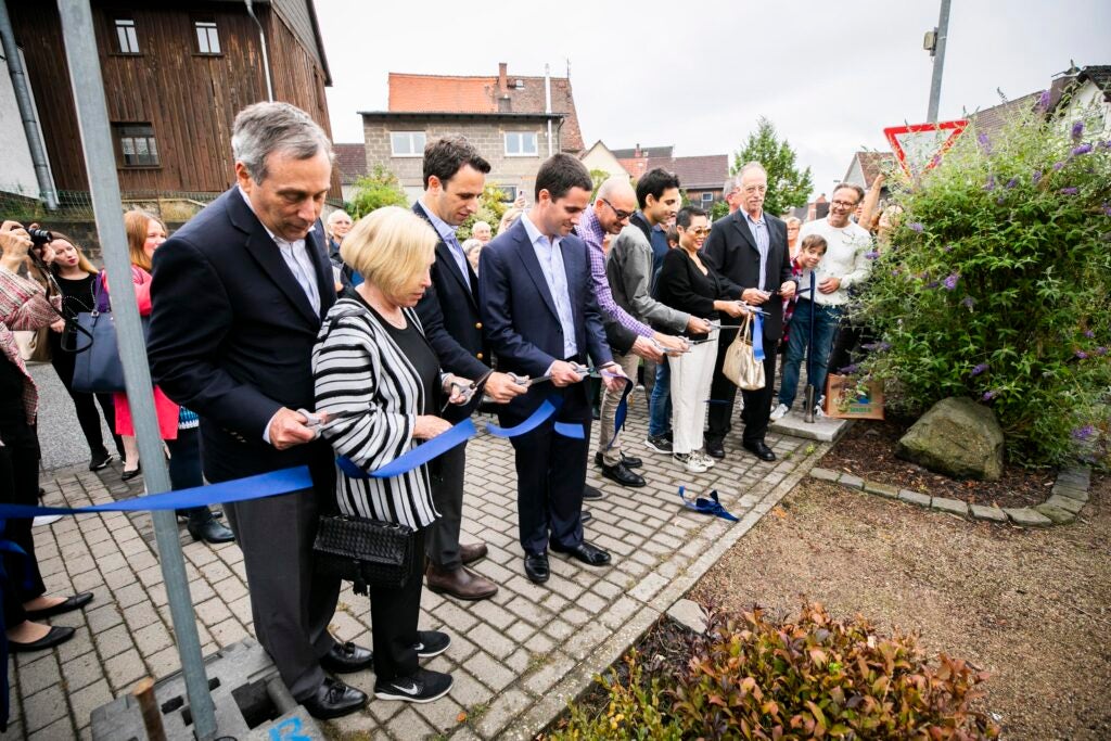 Larry Bacow cuts ribbon on Holocaust memorial in Londorf, Germany.