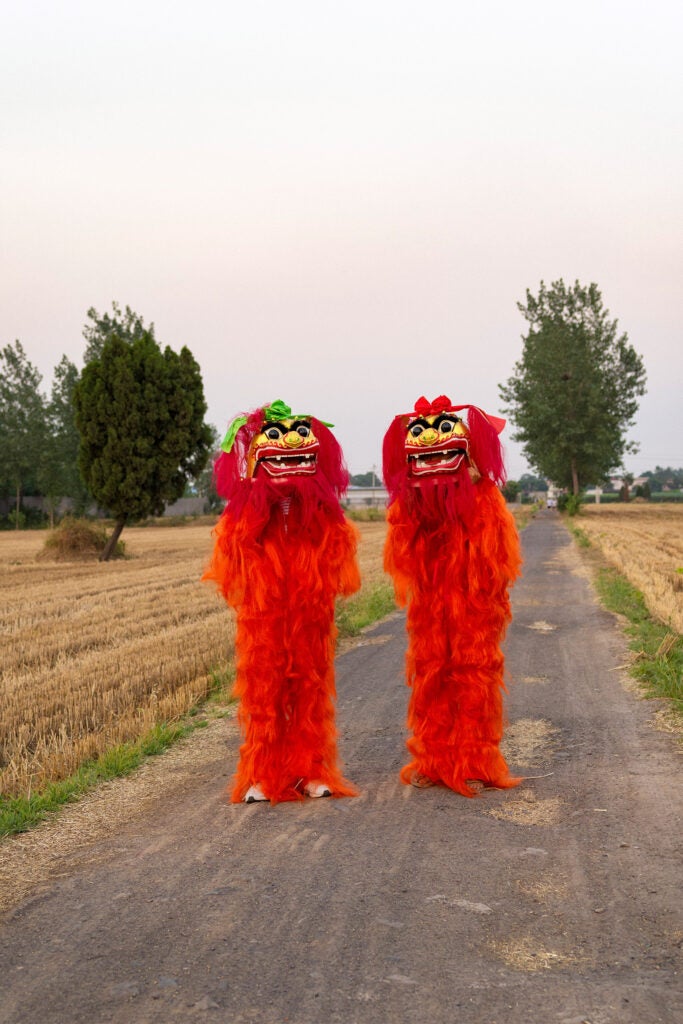 Two red lion performers in costume.