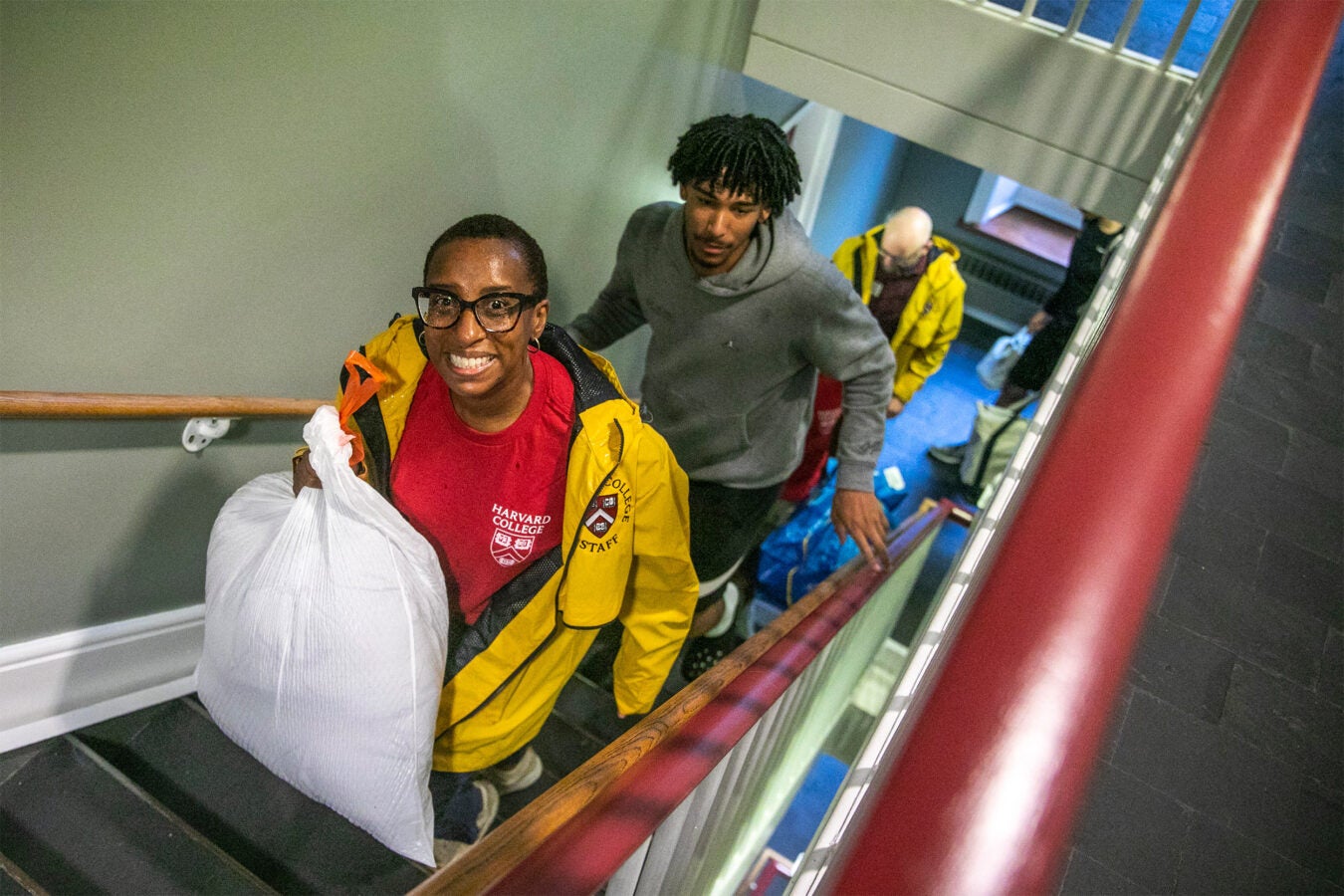 President Gay totes a bag up the stairs for first-year basketball player Thomas Lee Batties II.