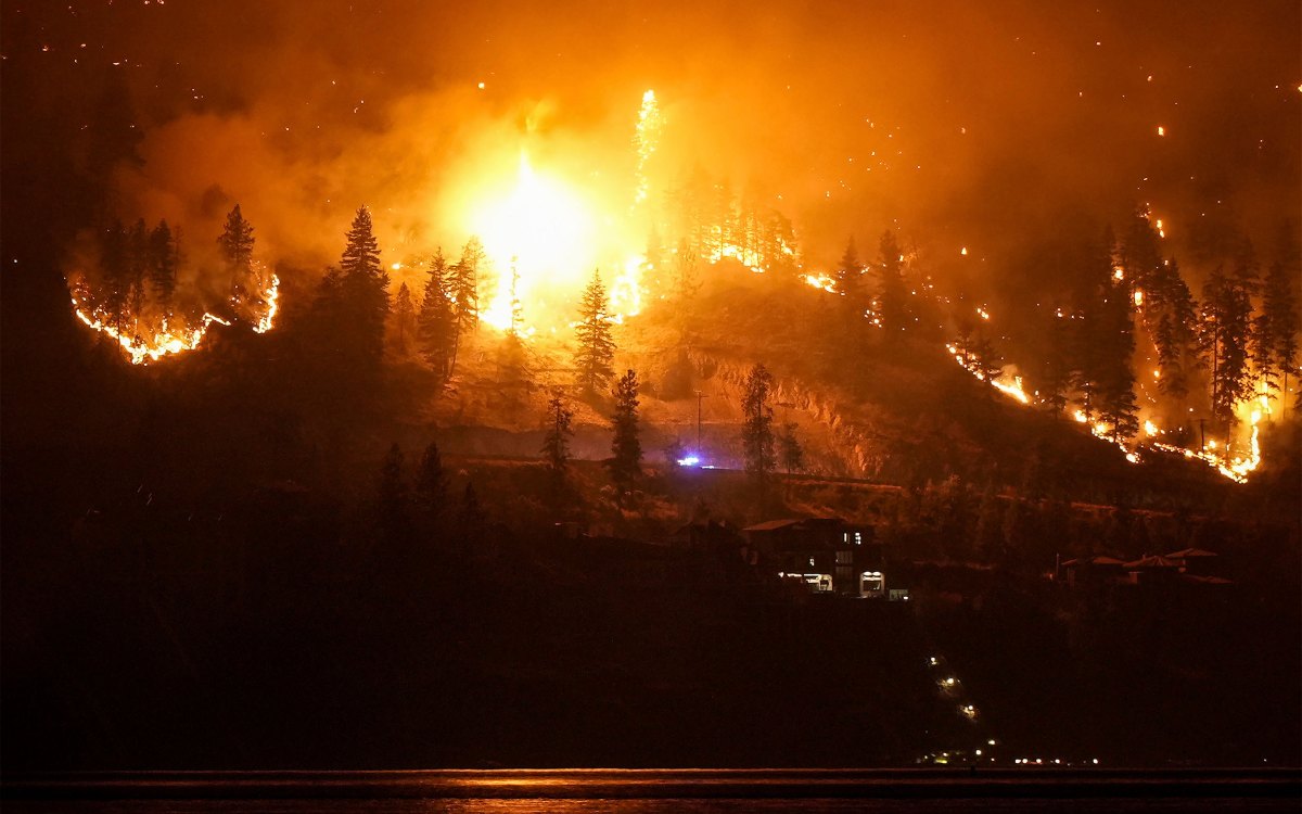 A wildfire burns on the mountainside in West Kelowna, Canada.