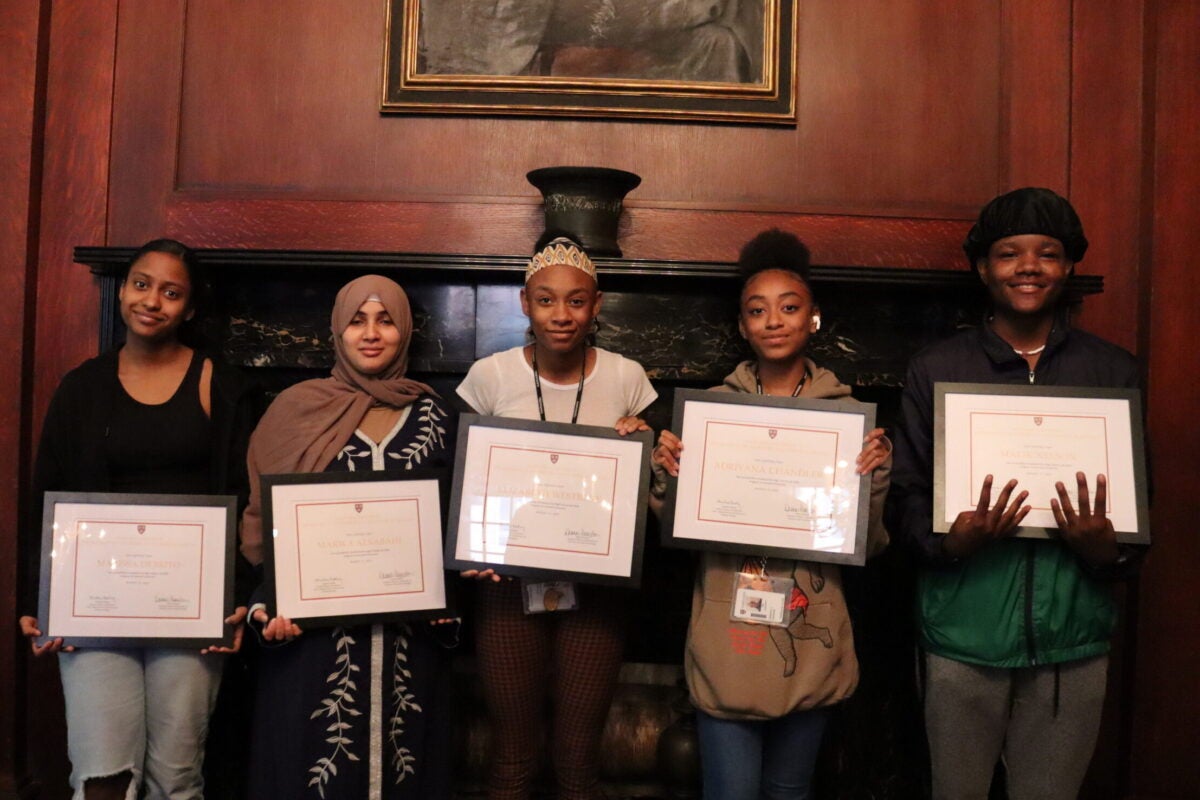Brighton High School students Marissa Debrito, Marwa Alsabahi, Elizabeth West Raye, Adriyana Chandler, and Malik Nelson hold their certificates of completion in front of a fireplace for the 2nd annual CCB High School Lab Skills summer internship program.