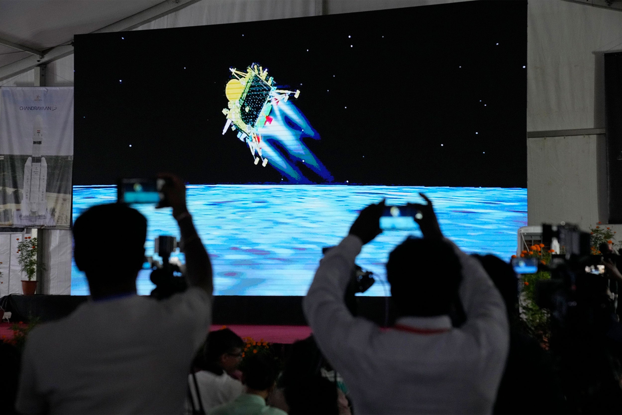 Journalists film the live telecast of spacecraft Chandrayaan-3 landing on the moon.