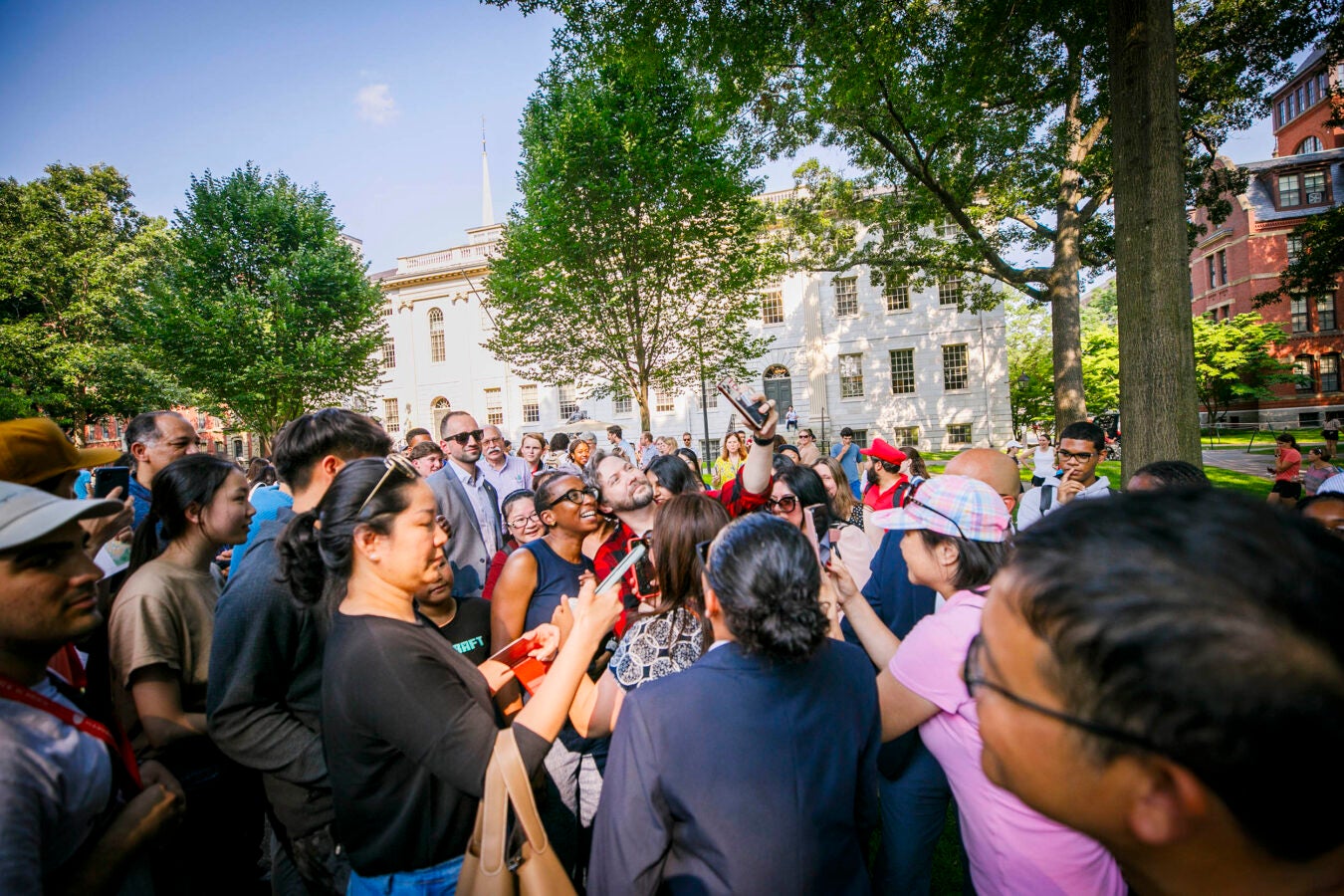 Crowd gathers around Harvard President Claudine Gay at an ice cream social in Harvard Yard.