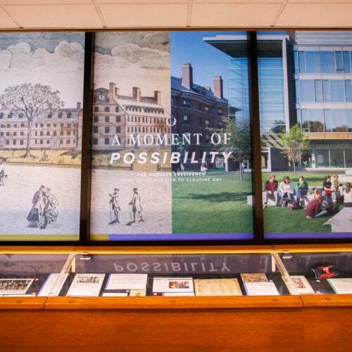 Main wall and glass case of an exhibition of historical items related to Harvard's presidency.
