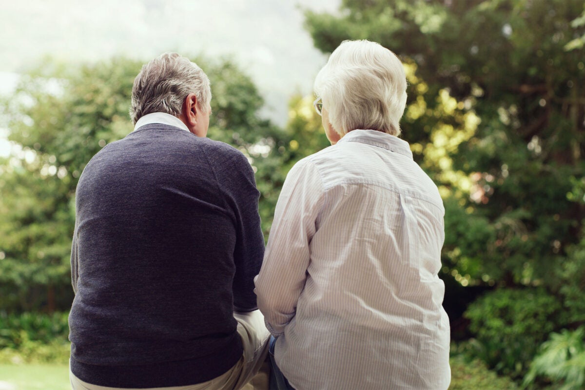 Elderly couple sitting on bench.