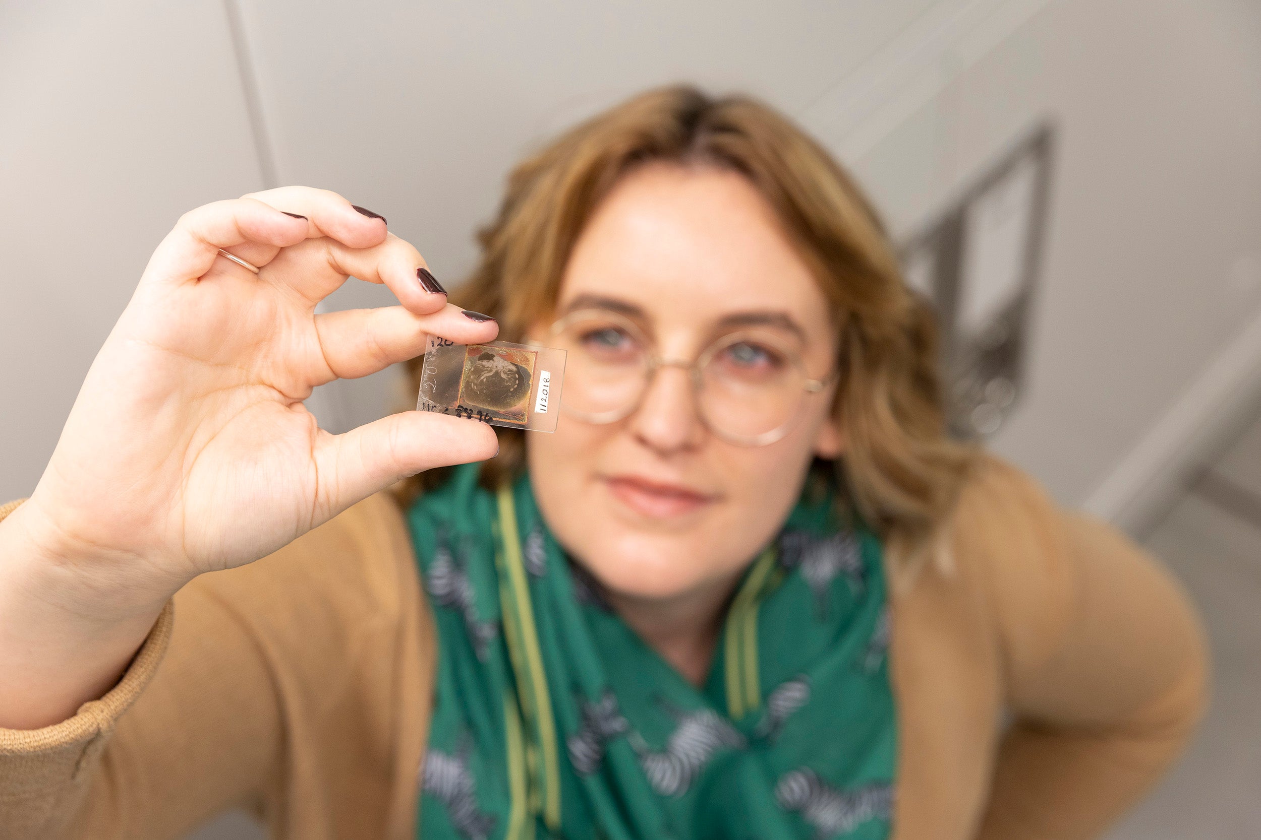 Sarah Losso (pictured) holds up a trilobite glass slide.
