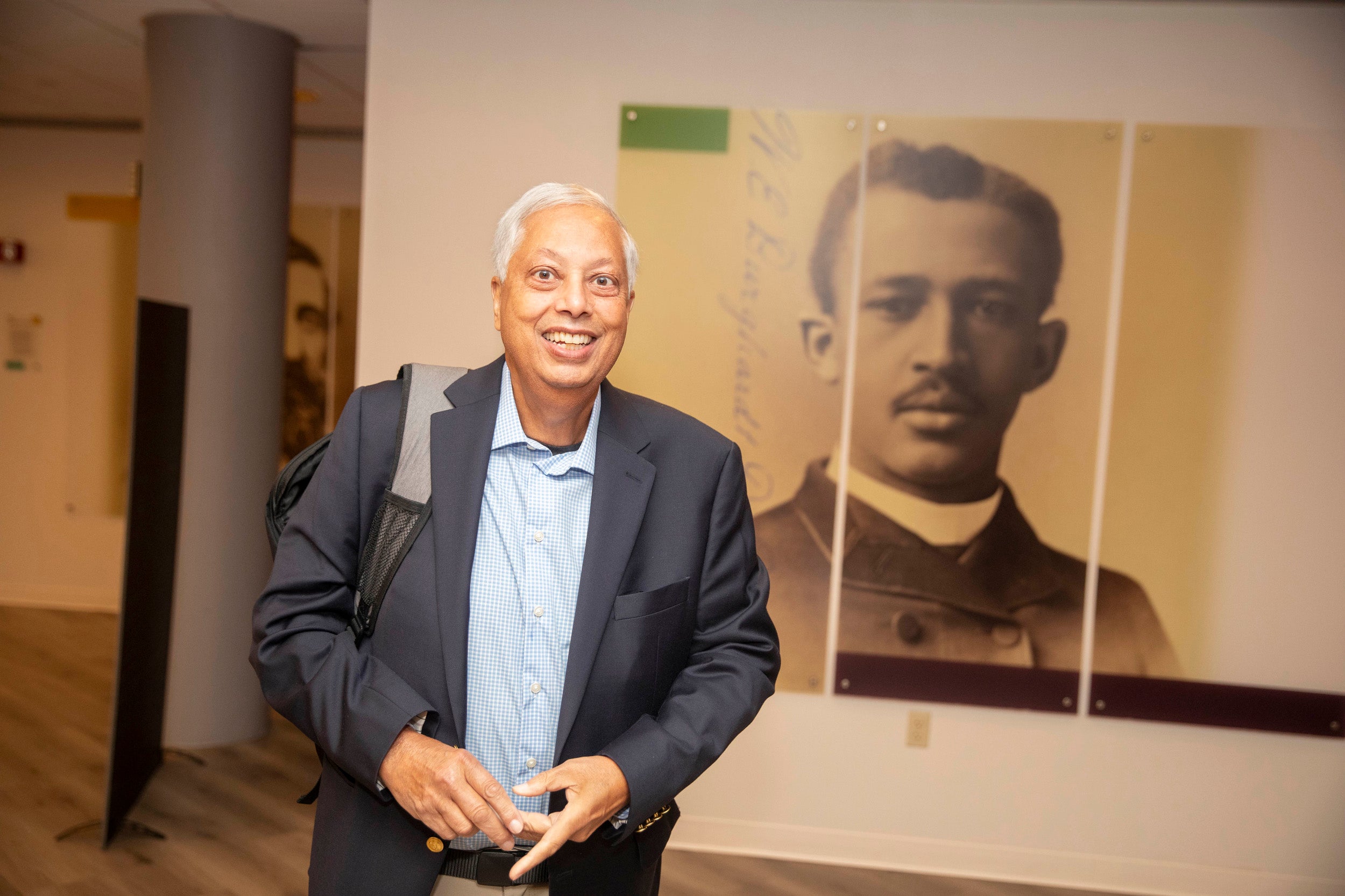 Lee Smith standing in front of a large photograph of photo of W. E. B. Du Bois.