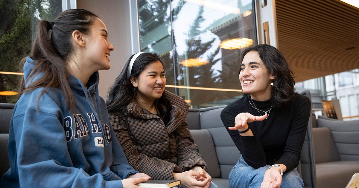 Gabrielle Grant ’24 (from left), Laurinne Eugenio ’26, and Eleanor Wikstrom ’24 chatting on a couch.