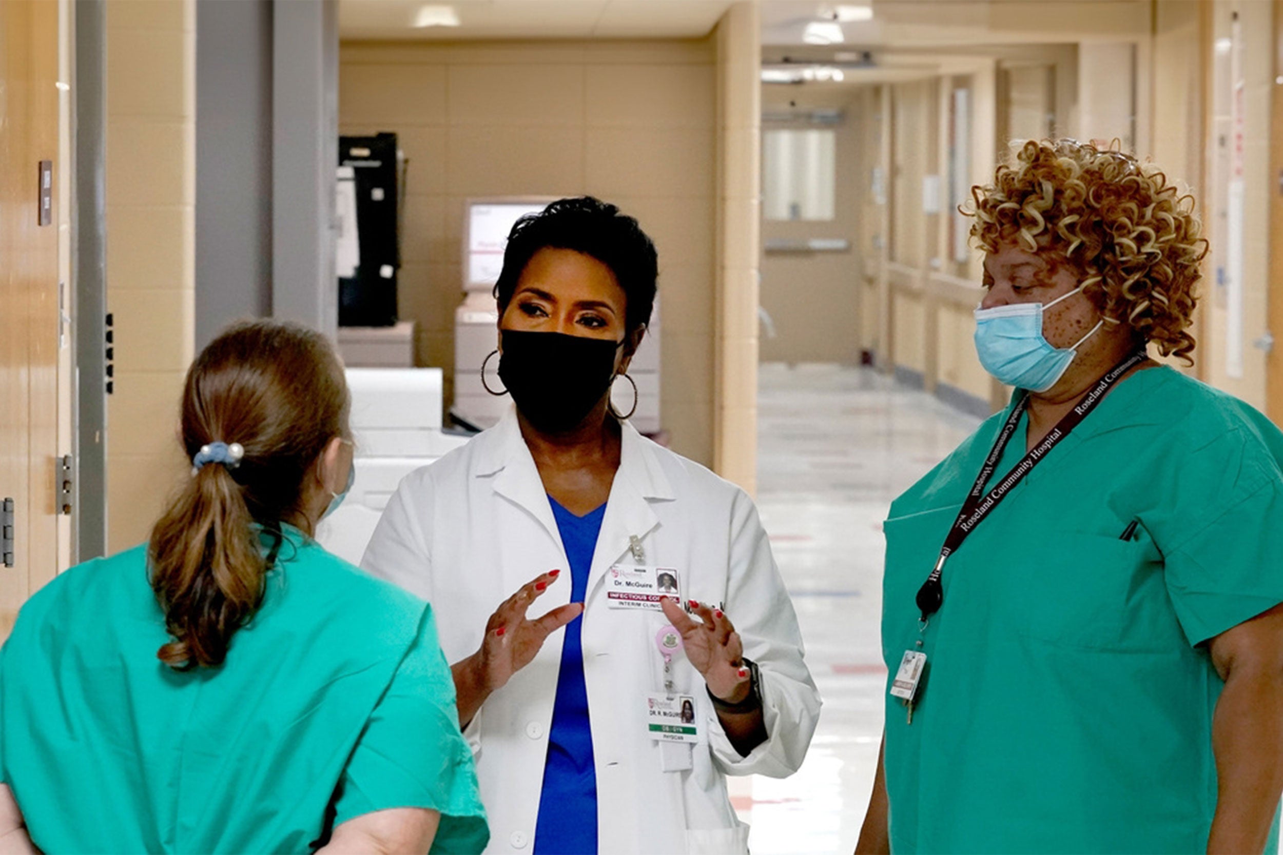 Doctors meeting in a hallway.