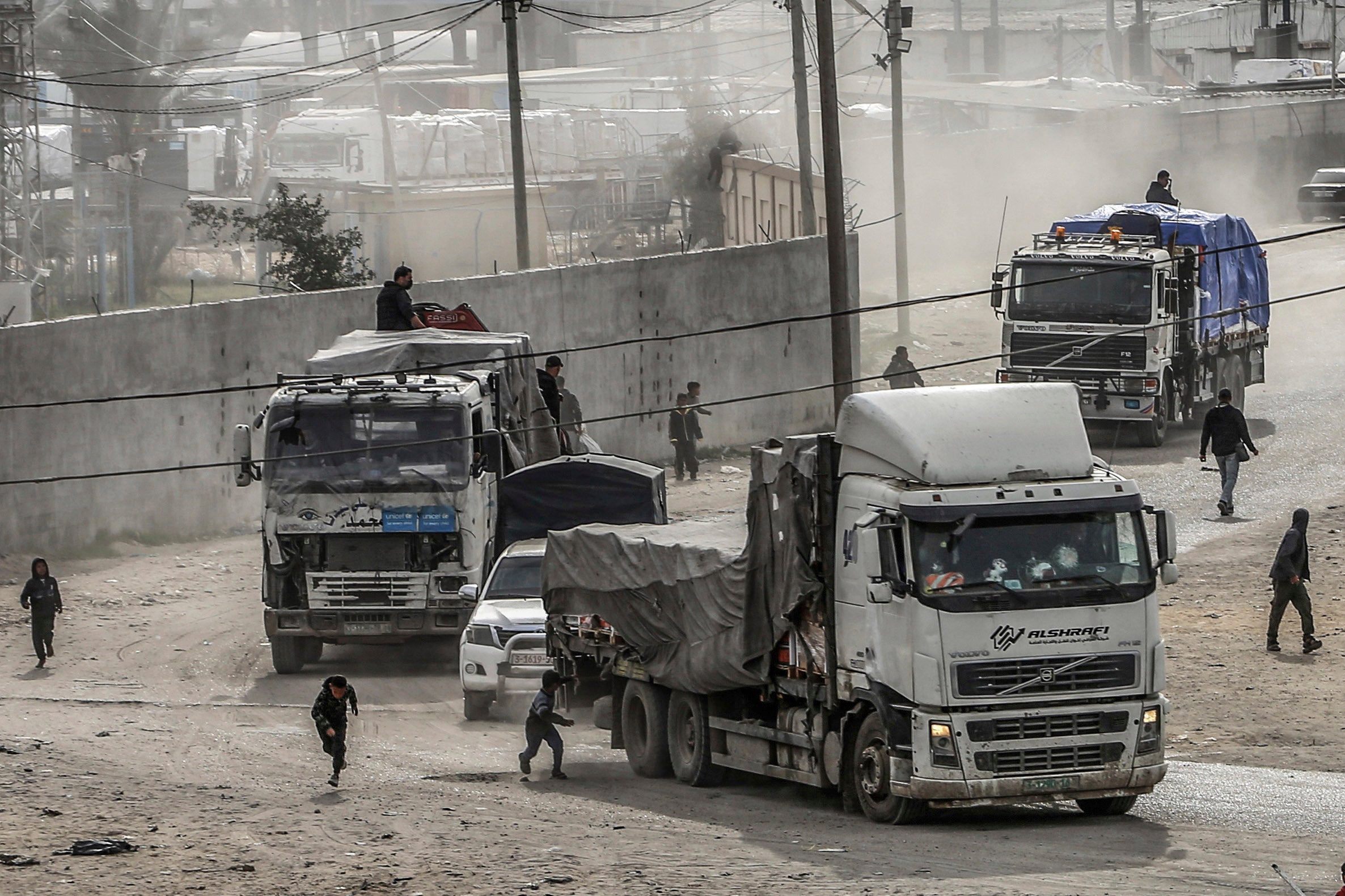 Trucks carrying humanitarian aid enter the Gaza Strip .