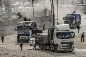 Trucks carrying humanitarian aid enter the Gaza Strip .