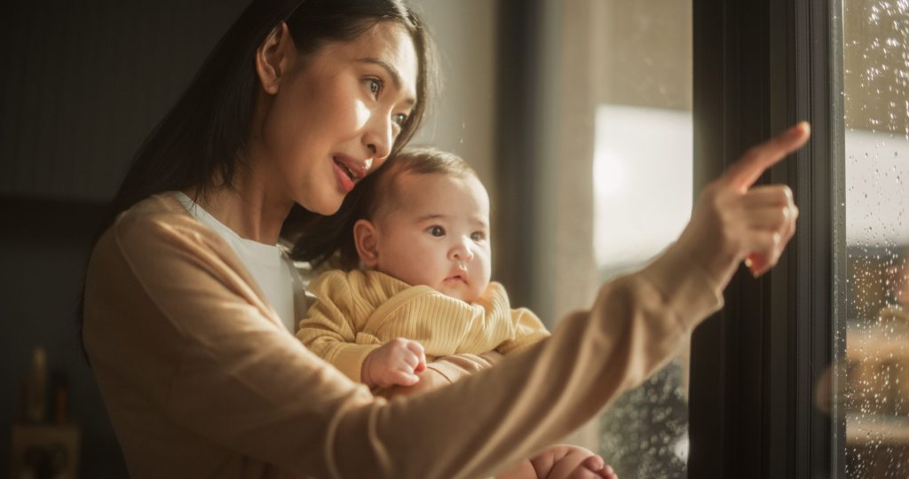 Mother pointing while talking to infant.