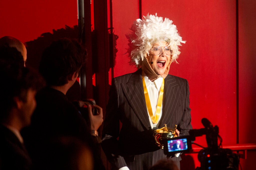Feather wigged Annette Bening excits with her