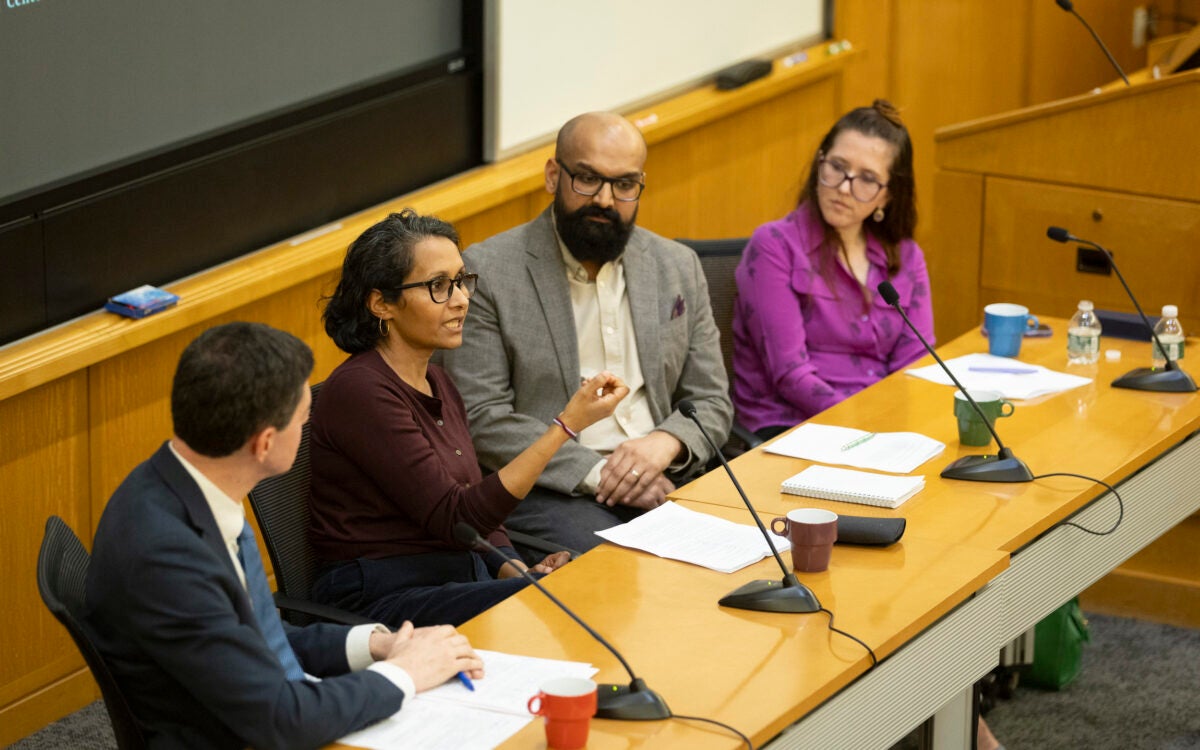 Eric Beerbohm (from left), Madura Rasaratnam, Mario Arulthas, and Kate Cronin-Furman sitting together in a lecture hall in front of microphones.