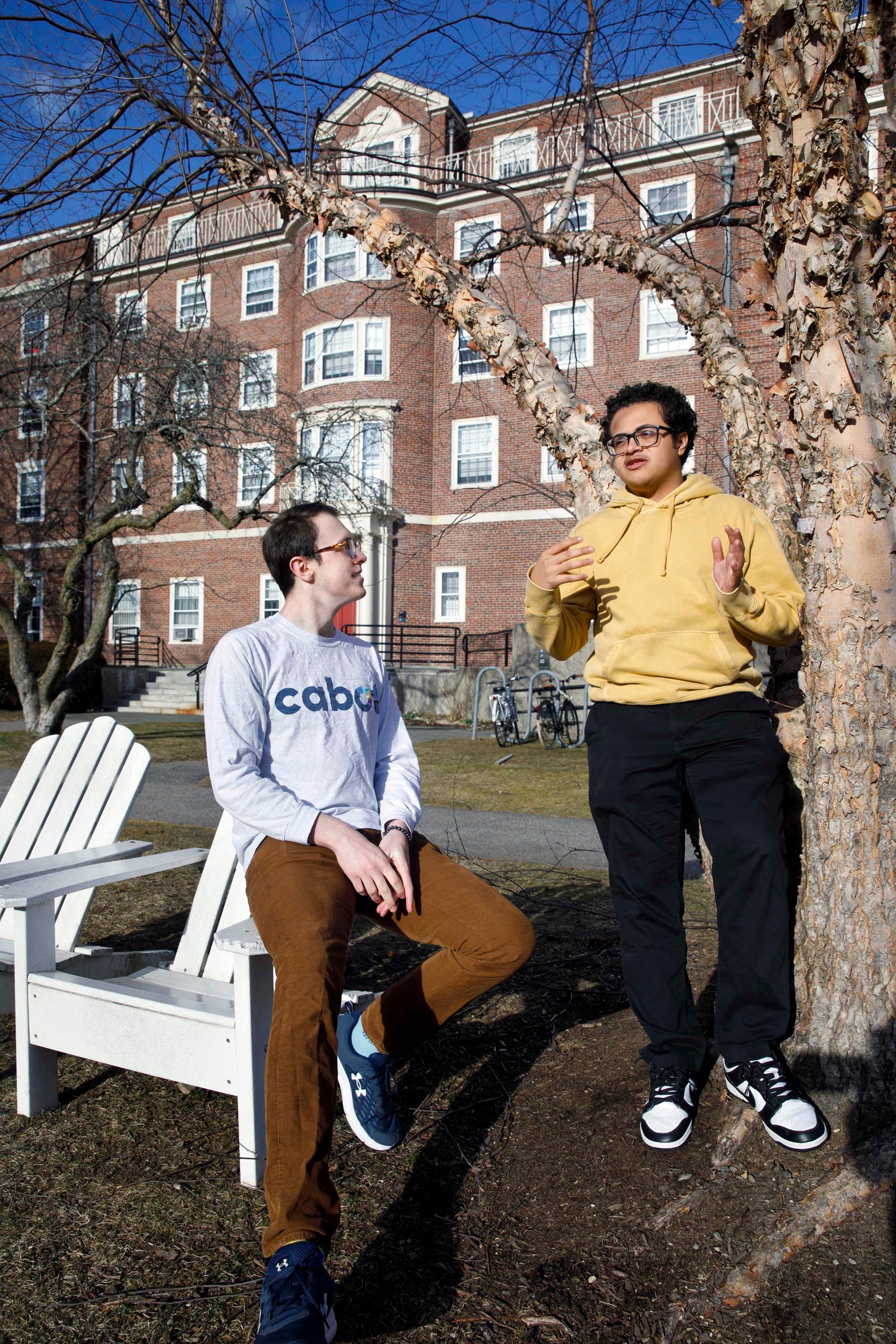House Committee chairs, Gabe LeBlanc ’25 and Chris Hidalgo ’25 (yellow shirt) relax in the Radcliffe Quadrangle outside Cabot Hall