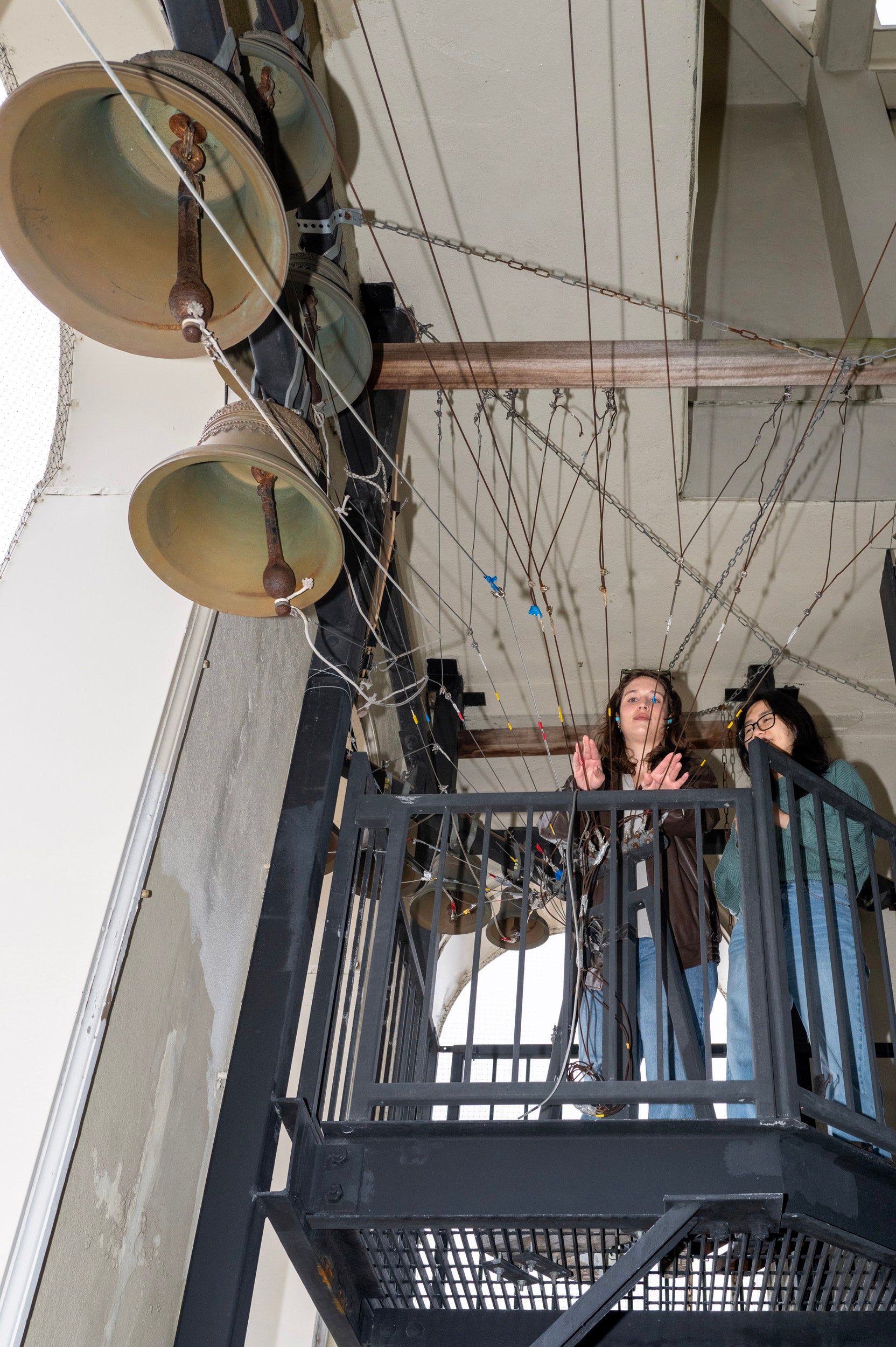 Lowell House Hocos Sofia Giannuzzi and Linh Vu ring a large bell in the Lowell House bell tower
