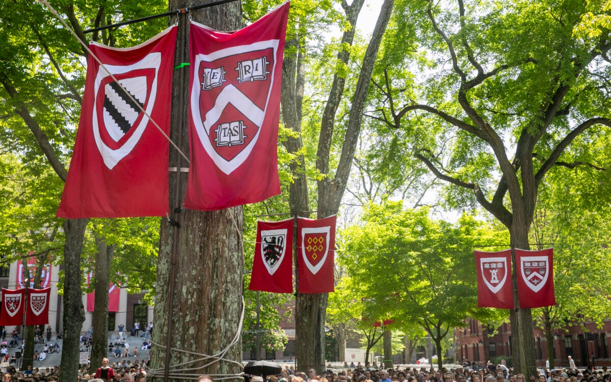 Harvard School banners above a Commencement crowd.