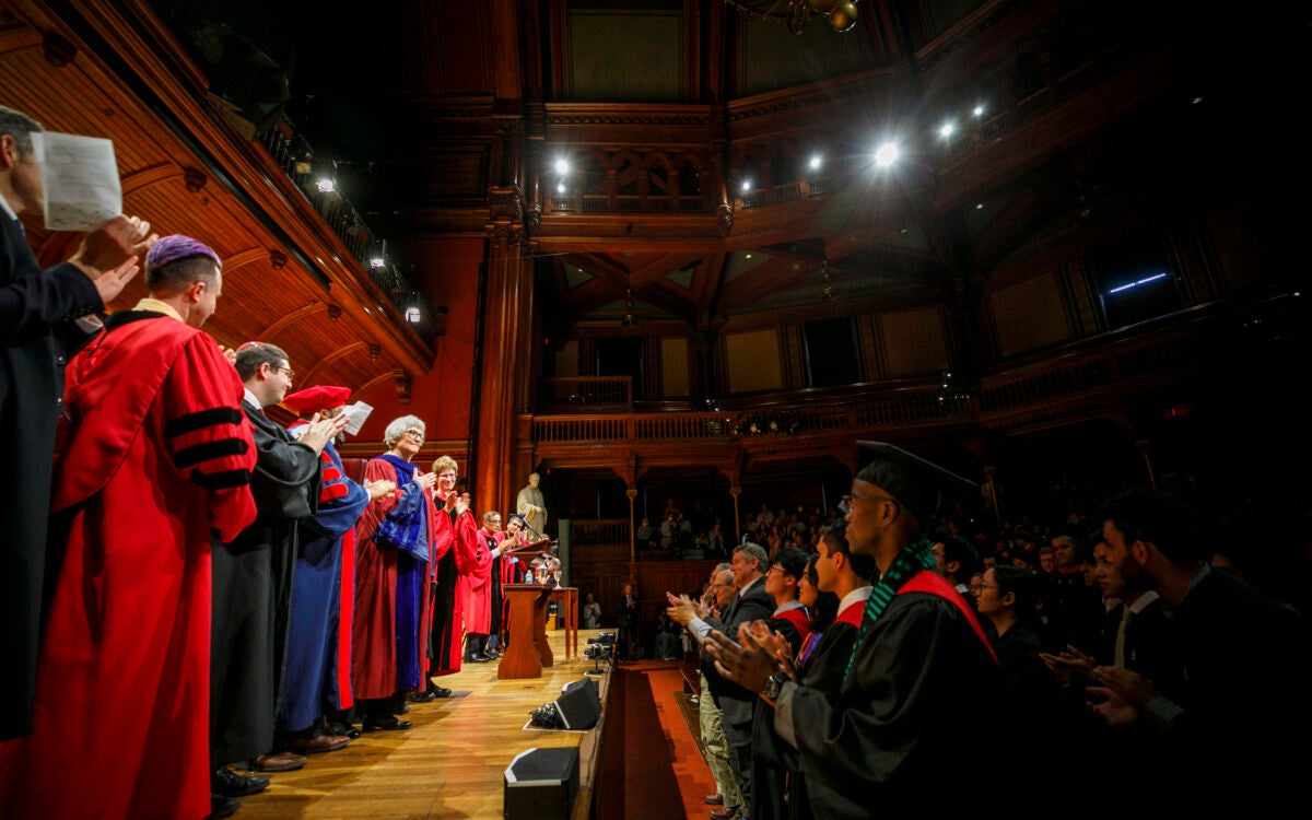 President Emerita Drew Faust (center) acknowledges the audience after receiving a standing ovation for her oration.