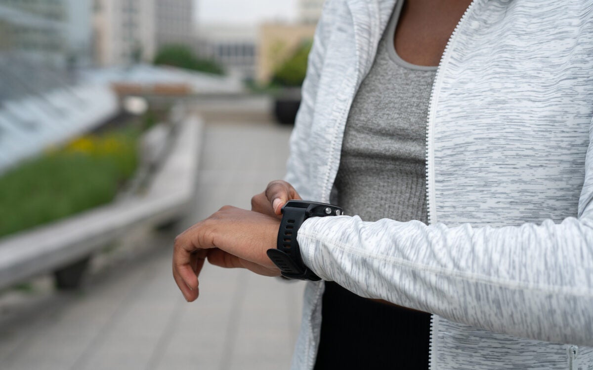 Close-up of a woman checking her smart watch while exercising.