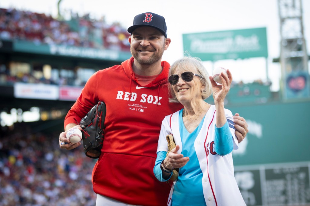 Claudia Goldin (right) signs a baseball for Liam Hendriks of the Red Sox after throwing the first pitch at Fenway Park. 