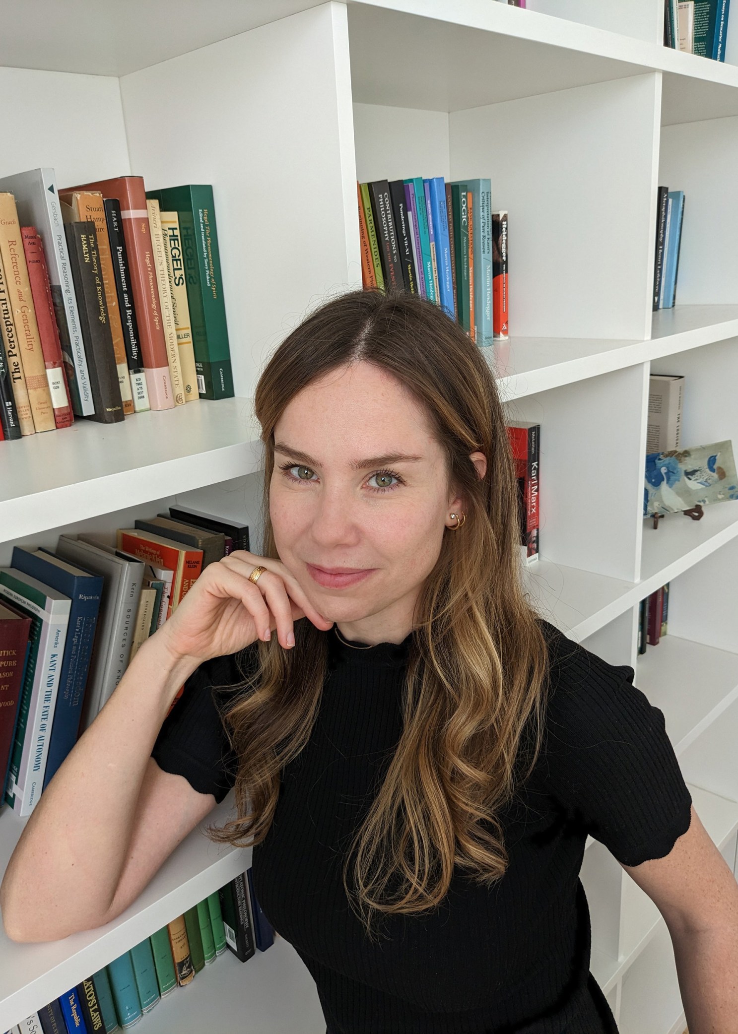 Anastasia Berg posing next to a bookcase.