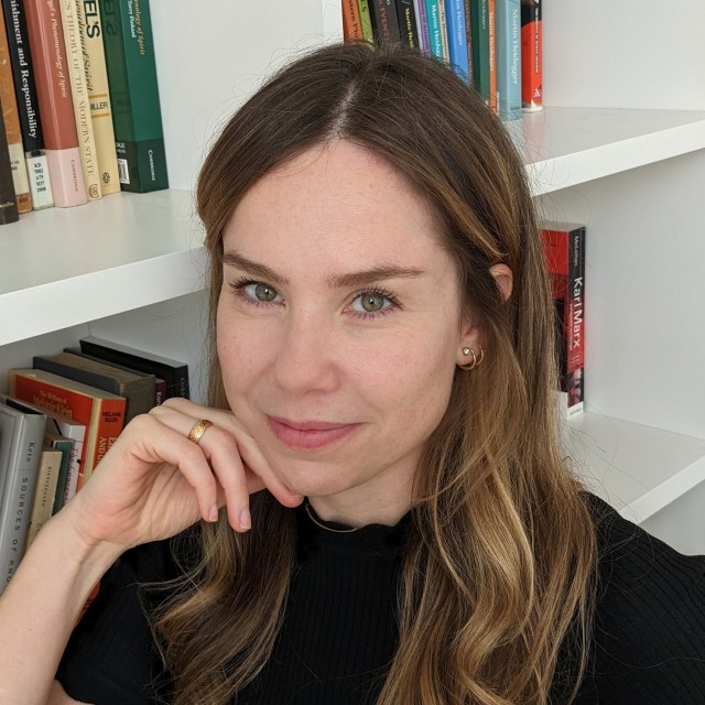 Anastasia Berg posing next to a bookcase.