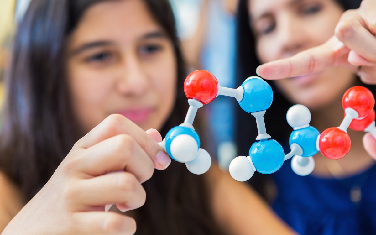 Mother teaching daughter about molecules.