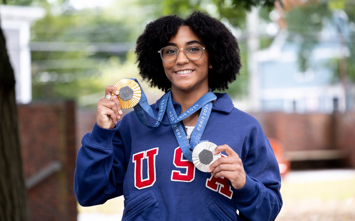 Lauren Scruggs Portrait holding up a silver and gold medal.